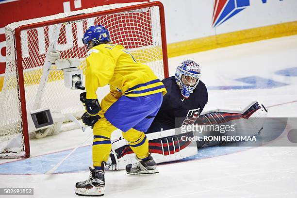 Alexander Nylander of Sweden scores 1-0 behind the goalkeeper Alex Nedeljkovic of USA during the 2016 IIHF World Junior Ice Hockey Championship match...