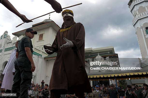 Member of the sharia police receives a cane as officials conduct punishment based on Islamic sharia law in Banda Aceh on December 28, 2015. Aceh is...