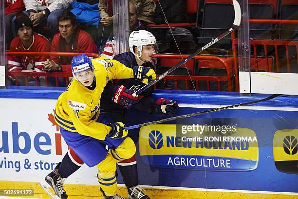 Sweden's Anton Karlsson holds US Zach Werenski during the 2016 IIHF World Junior Ice Hockey Championship match between Sweden and USA in Helsinki,...