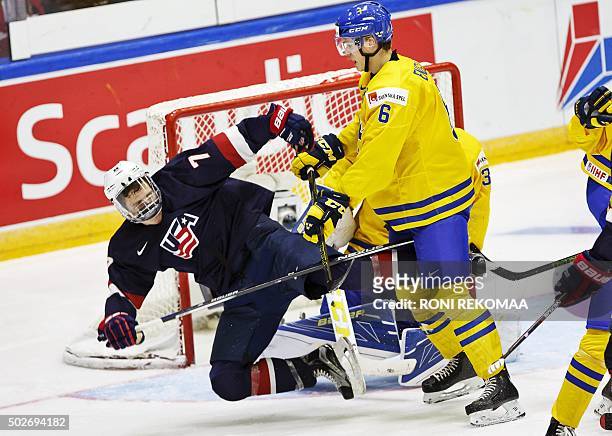 Sweden's Andreas Englund tackles US Matthew Tkachuk during the 2016 IIHF World Junior Ice Hockey Championship match between Sweden and USA in...