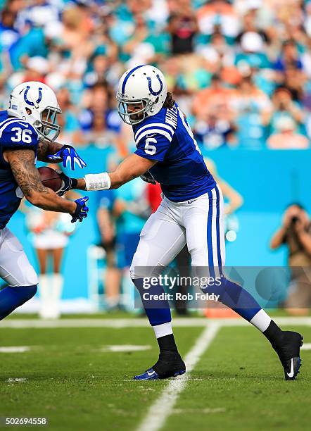 Charlie Whitehurst of the Indianapolis Colts hands the ball off to Dan Herron during the gam against the Miami Dolphins e at Sun Life Stadium on...