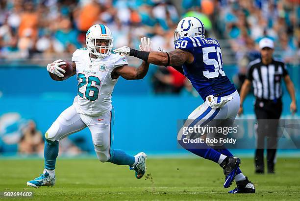 Lamar Miller of the Miami Dolphins is defended by Jerrell Freeman of the Indianapolis Colts during the game at Sun Life Stadium on December 27, 2015...