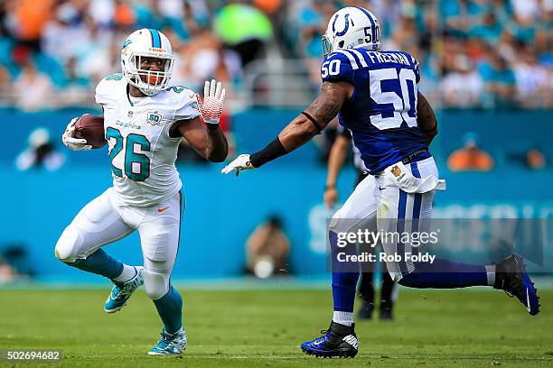 Lamar Miller of the Miami Dolphins is defended by Jerrell Freeman of the Indianapolis Colts during the game at Sun Life Stadium on December 27, 2015...