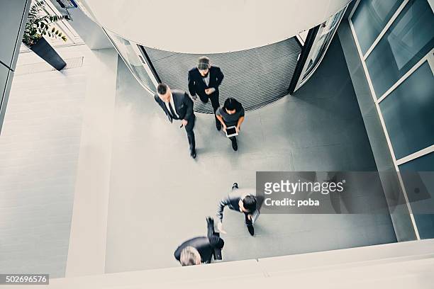 group of  businesspeople entering the lobby - entering stock pictures, royalty-free photos & images