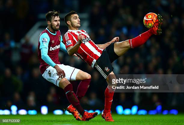 Dusan Tadic of Southampton holds off Carl Jenkinson of West Ham United during the Barclays Premier League match between West Ham United and...