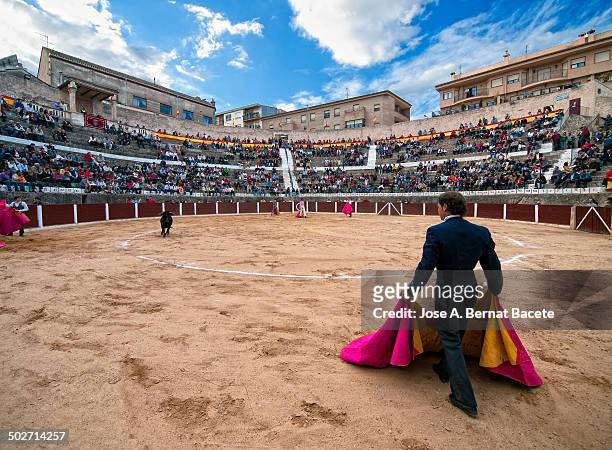 View Bocairent bullring , in a bullfight, bullfighter back with his cape and the steps of the crowded square. Bocairent, , Spain