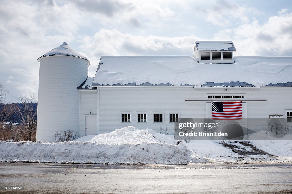 A white barn with an American Flag in Vermont