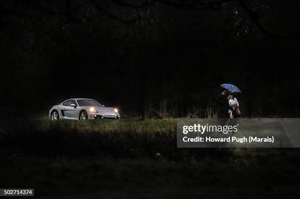 sports car headlights couple in the rain - im scheinwerferlicht gefangen stock-fotos und bilder