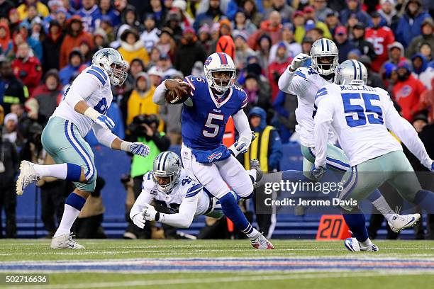 Tyrod Taylor of the Buffalo Bills eludes the tackle of a diving Barry Church of the Dallas Cowboys during the first half against the Dallas Cowboys...