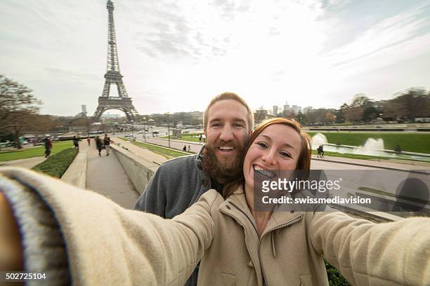 fröhlich junges paar macht selfie-porträt auf eiffelturm, paris - couple paris tour eiffel trocadero stock-fotos und bilder