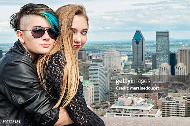 two rebel teenagers hugging in front of montreal cityscape. - 16 year old models stock pictures, royalty-free photos & images