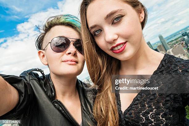 selfie of two rebel teenages in front montreal cityscape. - androgynous stock pictures, royalty-free photos & images