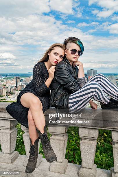 two rebel teenagers posing in front of montreal cityscape. - rebellion stock pictures, royalty-free photos & images