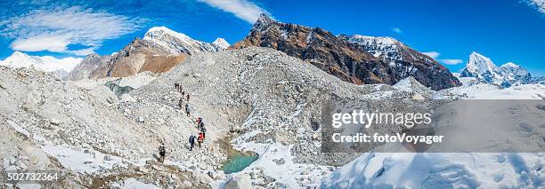 mountaineers crossing massive ngozumpa glacier beneath snowy peaks himalayas nepal - gokyo valley stock pictures, royalty-free photos & images