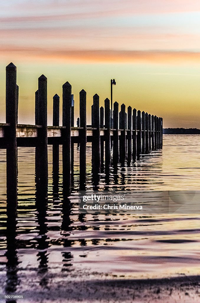 Dock, soft orange pastel sunset over water