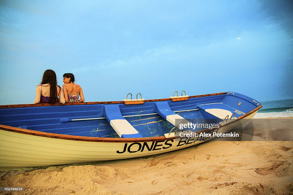 Two girls stay at the Jones Beach at the sunset