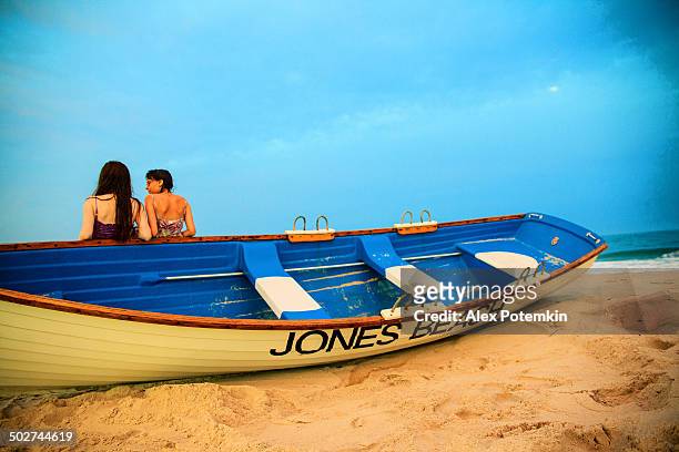 two girls stay at the jones beach at the sunset - jones beach stock pictures, royalty-free photos & images