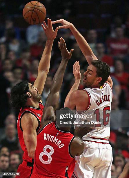 Pau Gasol of the Chicago Bulls passes over Luis Scola and Bismack Biyombo of the Toronto Raptors at the United Center on December 28, 2015 in...