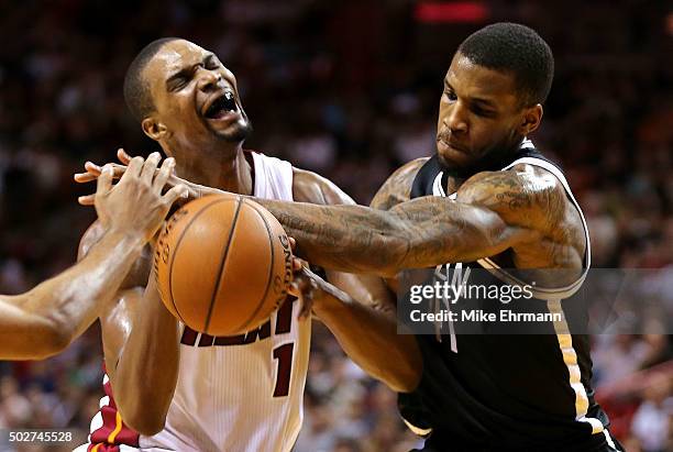 Chris Bosh of the Miami Heat has the ball stripped by Thomas Robinson of the Brooklyn Nets during a game at American Airlines Arena on December 28,...