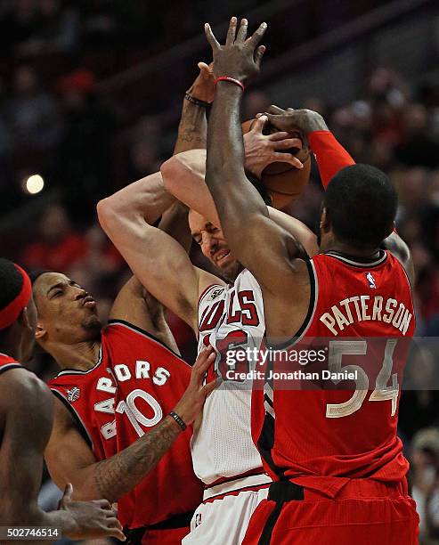 Pau Gasol of the Chicago Bulls is trapped by DeMar DeRozan and Patrick Patterson of the Toronto Raptors at the United Center on December 28, 2015 in...