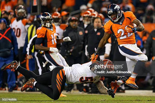 Running back C.J. Anderson of the Denver Broncos breaks away from a tackle attempt by middle linebacker Rey Maualuga of the Cincinnati Bengals as he...