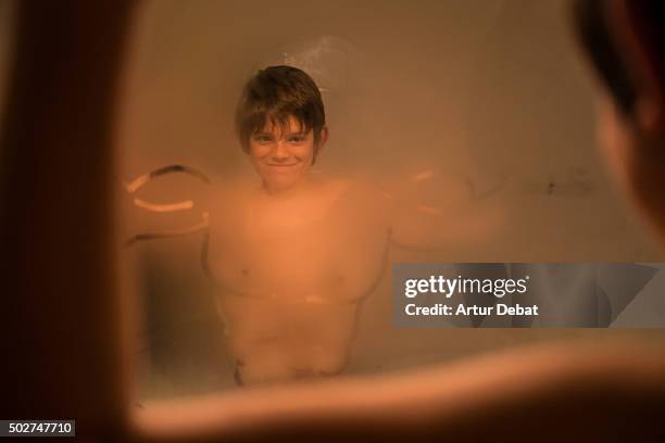 funny kid in front of mirror bathroom with muscled man drawn on the surface. - brustmuskulatur stock-fotos und bilder