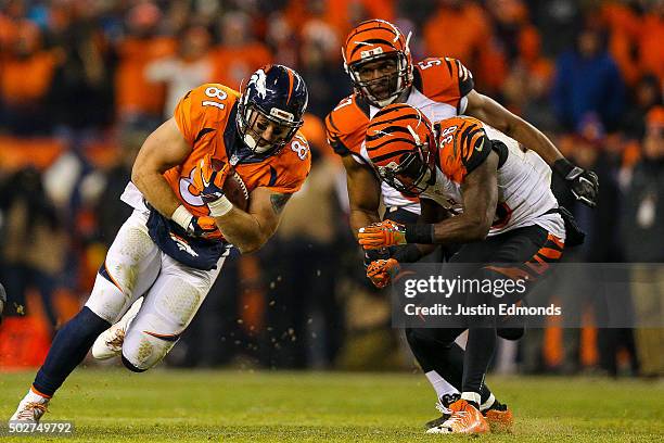 Tight end Owen Daniels of the Denver Broncos dives forward after a reception as cornerback Shawn Williams and outside linebacker Vincent Rey of the...