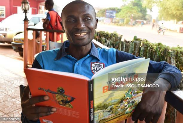 Central African cartoonist Didier Kassai presents on December 29, 2015 in Bangui, his new animated book "Tempete Bangui" which sets the stage...