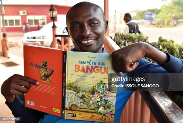 Central African cartoonist Didier Kassai presents on December 29, 2015 in Bangui, his new animated book "Tempete Bangui" which sets the stage...