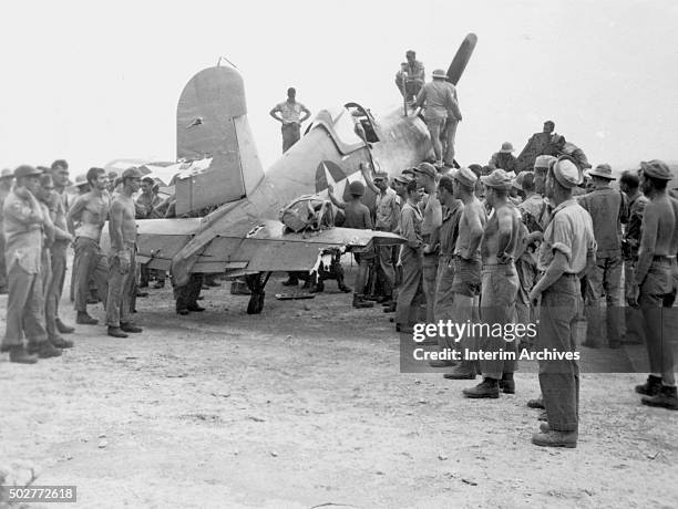 Navy Seabees and Marines pose beside Vought F4U Corsair with a heavily damaged tail, Bougainville Island, Papua New Guinea, 1944.