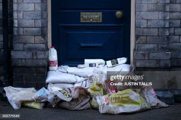 Bottles of milk delivered to a property are left on top of sandbags placed as defences in the aftermath of flooding in York, northern England, on...