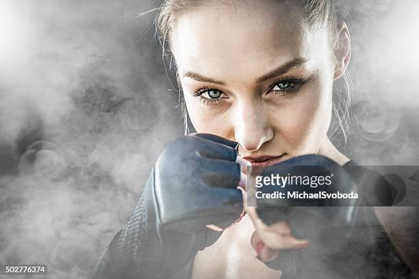 mma fighter on a smokey  background - female fist fights stockfoto's en -beelden