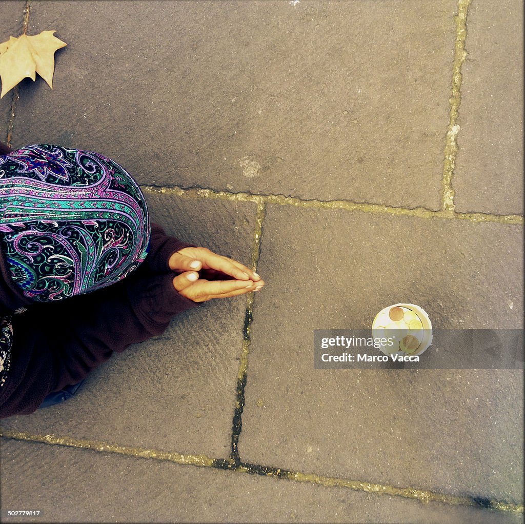 Woman begging on a sidewalk