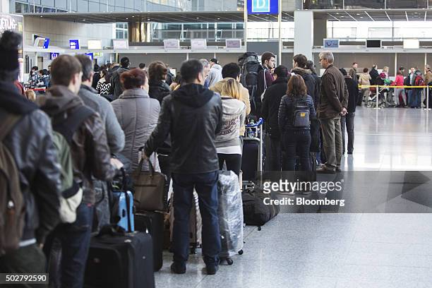 Passengers queue at a check-in counter, operated by TUI AG, inside Frankfurt Airport, operated by Fraport AG, in Frankfurt, Germany, on Monday, Dec....