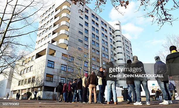 Asylum-seekers queue outside the State Office of Health and Social Affairs registration centre in Berlin on December 29, 2015. Germany's federal...