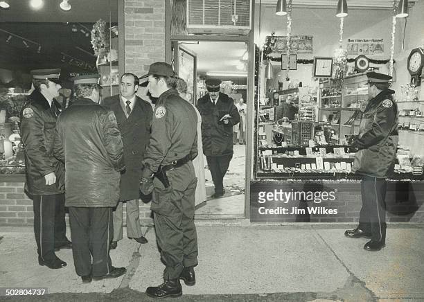 Shooting scene: Sergeant Julian Fantino of the Metro police homicide squad confers with other officers outside the store where jeweller Israel...