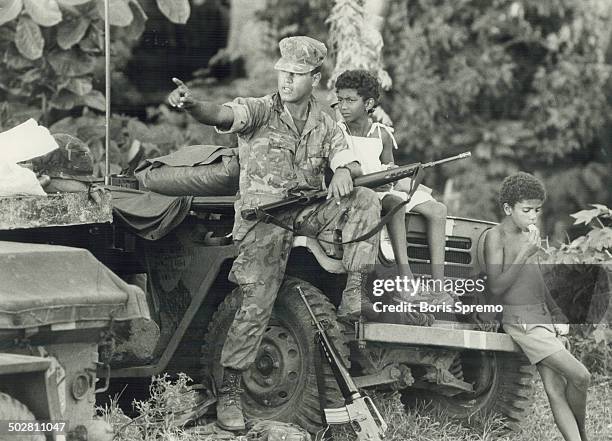 Friendly invader: U.S. Soldier takes time out to chat with two Grenadian children during joint U.S.-Caribbean nations' invasion of Grenada last week....