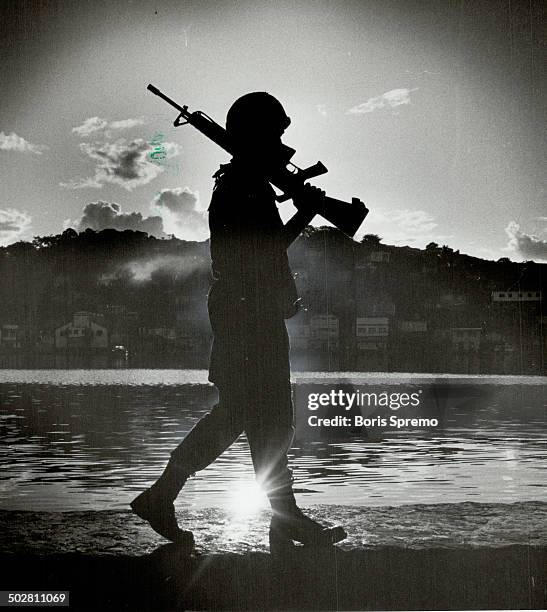 On guard: A U.S. Marine patrols the waterfront in downtown St. George's Grenada; at sunrise last november; after the marines invaded the tiny...