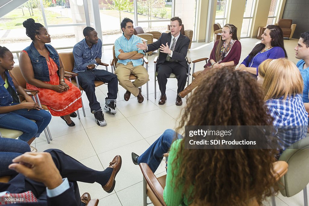 Man talking to diverse group of people during therapy session