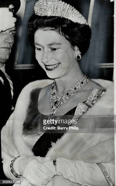 Our radiant Queen captured by the camera as she leaves the State dinner in Charlottetown yesterday. Beside the tiara; she is wearing a diamond and...