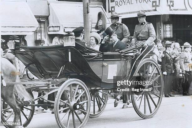 The Queen and Prince Philip ride up University Ave. From the Royal York Hotel to Queen's Park in the province's landau with the Ontario coat of arms...