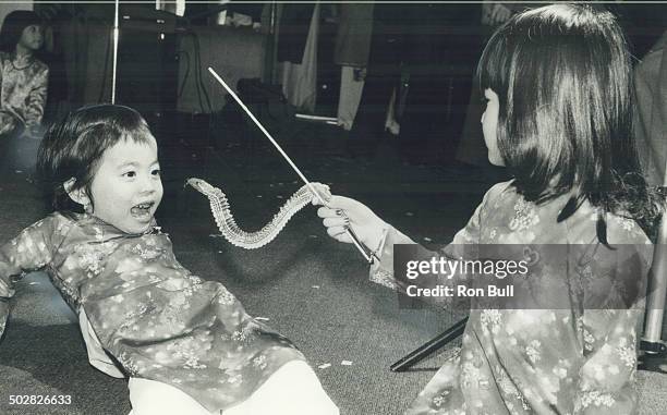 Happy new year: Anh Le; 4; wriggles a paper snake at her cousin; Loan Nguyen; also 4; as they get into the spirit of the Vietnamese Tet .