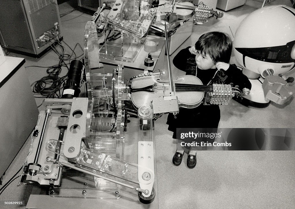 Play it again; Robot. Mariko Macksey; 4; listens as a robot plays violin at the Ontario Science Cent