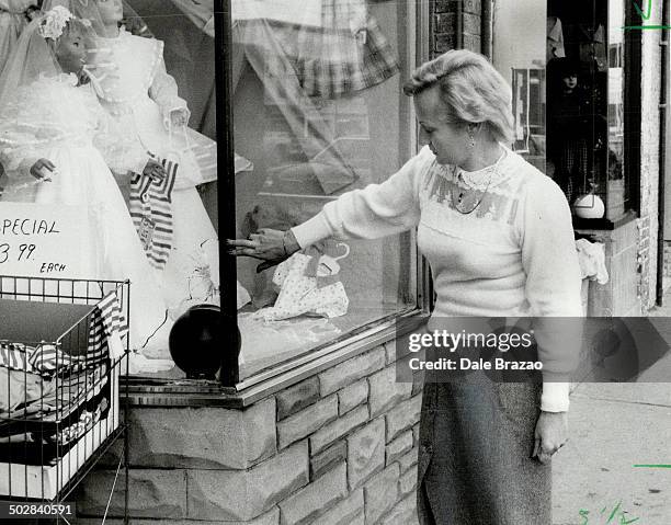 Robbery aftermath: Mirelle Durante; owner of Luisella Children's Wear on St. Clair Ave. Near Dufferin; points to bullet hole made by police after...