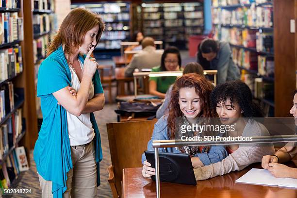 librarian tells students to be quiet in school library - librarian stock pictures, royalty-free photos & images