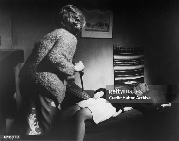 Geraldine Page holds a knife as Rosemary Forsyth sleeps in a scene of the movie "What Ever Happened to Aunt Alice?" circa 1969.
