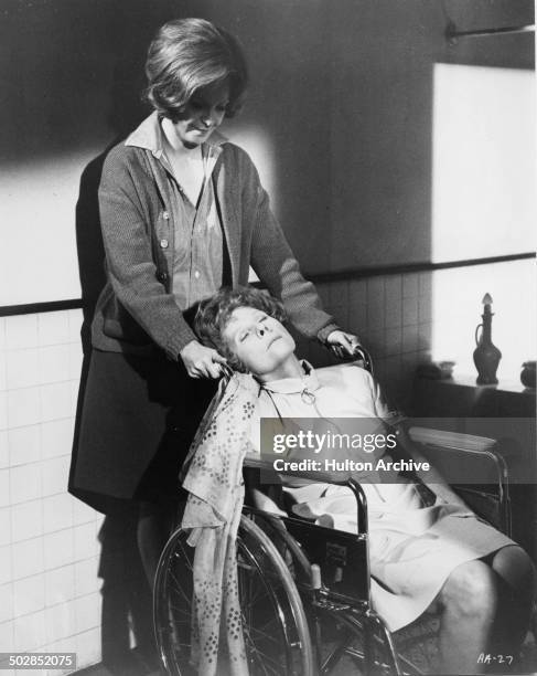 Rosemary Forsyth pushes Ruth Gordon in a wheelchair in a scene of the movie "What Ever Happened to Aunt Alice?" circa 1969.