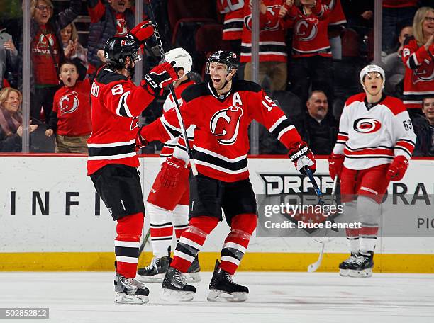 David Schlemko of the New Jersey Devils celebrates his game winning goal at 16:55 of the third period against the Carolina Hurricanes and is joined...