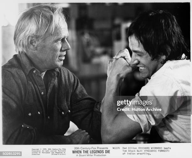 Richard Widmark arm wrestles Frederic Forrest in a scene from the 20th Century Fox movie "When the Legends Die" circa 1971.