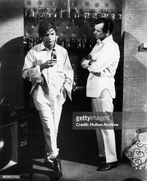 Robert Drivas accepts a drink from this father David Janssen in a scene for the United Artist movie "Where It's At" circa 1968.